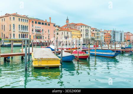 Kleine Boote, die an Holzpfählen auf dem Canal Grande in der Altstadt von Venedig, Italien, mit historischen Palästen und Gebäuden am Wasser vor Anker liegen. Traditioneller Kanal Stockfoto