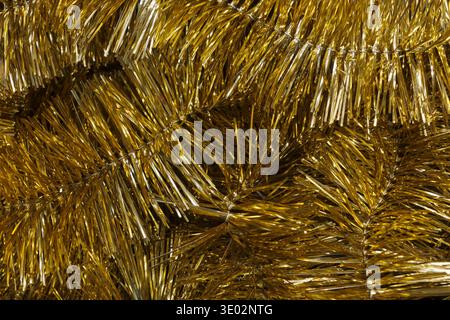 Urlaubshintergrund mit glänzenden goldenen Weihnachtsgirlanden. Weihnachtshintergrund mit Weihnachtslametta und Platz für Text Stockfoto