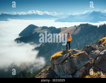 Frau mit Rucksack auf Bergrücken über einem Wolkenmeer Stockfoto