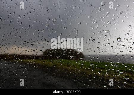 Schauerwetter bei Ense vom 10.03.2026 Regentropfen haften an einer Fensterscheibe, während eine verregnete Landschaft im Hintergrund verschwommen zu erkennen ist. *** Schauerwetter nahe Ense am 10 03 2026 Regentropfen Klammern sich an einer Fensterscheibe an, während eine regnerische Landschaft im Hintergrund unscharf zu sehen ist Copyright: xx xChantalxAndersx Stockfoto