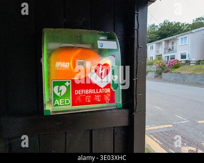 St Dogmaels, Cardiganshire, Wales, Vereinigtes Königreich - 26. Juli 2025: AED-Defibrillatorausrüstung zur Unterstützung von Herzinfarkten in einem Container an einer Bushaltestelle Stockfoto