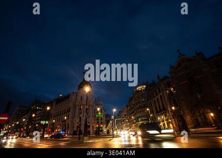 Das Metropolis-Gebäude an der berühmten Kreuzung von Calle Alcalá und Gran Via in Madrid. Dramatische Wolken erfüllen den tiefblauen Himmel Stockfoto