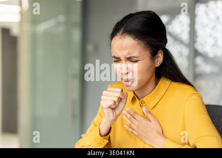 Junge Frau, die an Husten und Halsschmerzen leidet, Symptome von Grippe oder Erkältung im Büro zeigt, Beschwerden und Schmerzen durch Krankheit erlebt Stockfoto