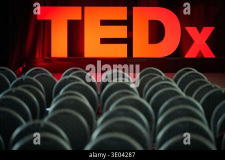 Großes beleuchtetes TEDx-Schild auf einer Bühne hinter Reihen leerer Stühle vor der TEDx-Sopot-Konferenz in Sopot, Pommern, Polen, Europa. Stockfoto