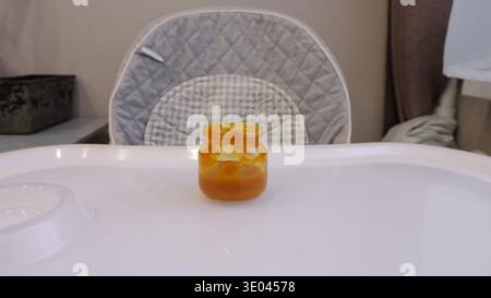 Farbenfrohe Marmelade In Einem Kleinen Glas Mit Essbarer Blumendekoration Wunderschön Dargestellt. Herrliche Frühstücksszene Mit Heller Orangenmarmelade In Glas Stockfoto