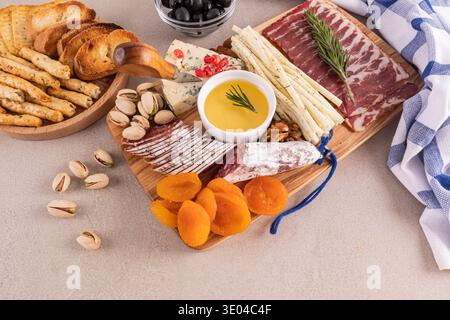 Eine wunderschön angeordnete Gourmet-Wurstplatte mit einer Auswahl an Käse, Wurstwaren, getrockneten Früchten, Nüssen und Oliven. Perfekt für Eleganz Stockfoto
