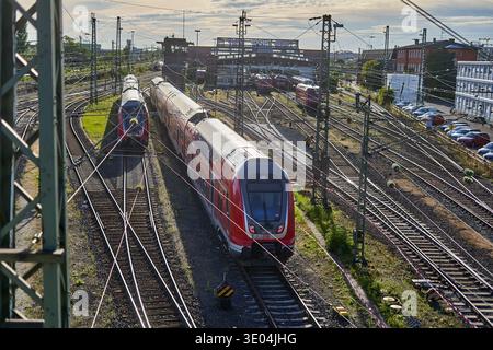 Luftaufnahme eines stark frequentierten Eisenbahnknotens in Frankfurt, Deutschland, mit zwei modernen roten Personenzügen der Deutschen Bahn auf konvergierenden Gleisen. Die... Stockfoto