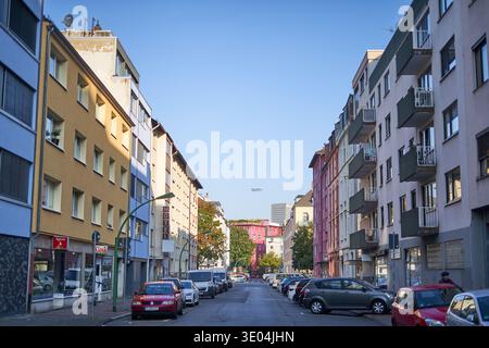 Eine lebhafte Straßenszene in Frankfurt, Deutschland, mit farbenfrohen Wohn- und Geschäftsgebäuden an beiden Seiten einer ruhigen Stadtstraße. Die... Stockfoto
