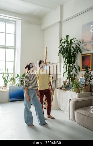 Verheiratete Künstlerpaare, die gemeinsam in der Werkstatt der Galerie Wandgemälde sehen Stockfoto