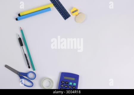 Schulzubehör und ein Taschenrechner auf einem weißen Tisch Stockfoto
