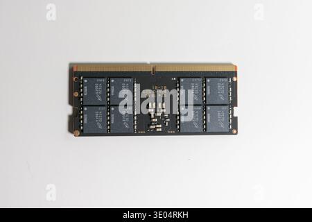 Nahaufnahme eines schwarzen DDR5-RAM-Sticks mit Goldkontakten und integrierten Schaltungen, isoliert auf weiß. Stockfoto