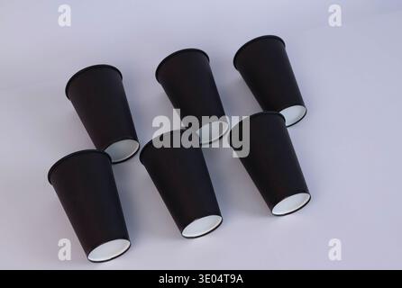 Schwarze Gläser diagonal auf einem weißen Tisch angeordnet Stockfoto
