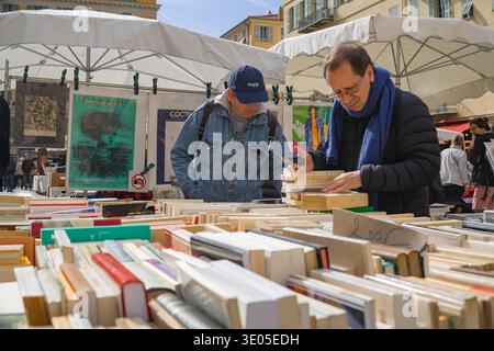 Marché à la Brocante et aux Livres am Place du Palais de Justice, Nizza, Frankreich. Sammler untersuchen alte Bücher und Plakate auf dem Freiluftmarkt. Stockfoto