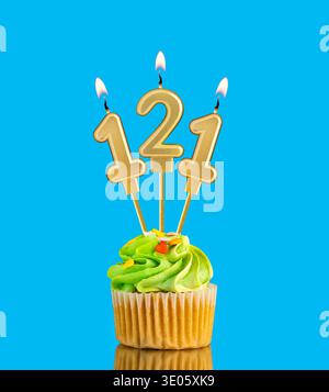 Kerze Nummer 121 - Geburtstagskarte mit Cupcake auf blauem Hintergrund Stockfoto