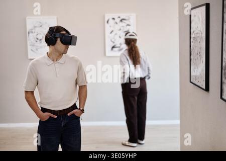 Junger Kaukasischer Mann Mit Virtual Reality Headset, Der Kunstausstellung Beobachtet Stockfoto
