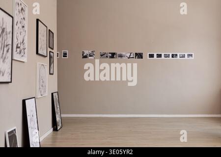 Leere Kunstgalerie mit Schwarzweiß-Fotografien auf beigefarbener Wand Stockfoto
