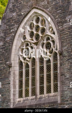 Außenfenster der Kirche im Gothic Revival mit Lanzettenleuchten, kreisförmigem Tracery und bleihaltigen Scheiben an der Kylemore Abbey Church, County Galway, Irland. Stockfoto