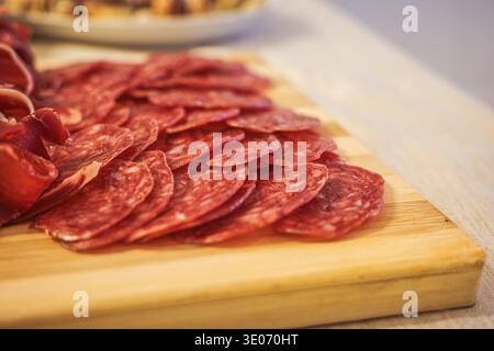 Iberische Chorizo-Scheiben auf Holzbrett Nahaufnahme spanische Wurst Stockfoto