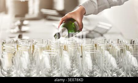 Der Kellner gießt Champagner in Gläser auf der Party Stockfoto