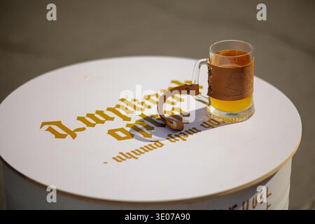 Glasbecher mit Craft Beer und Lederhalter auf dem Markentisch beim Jerewan Beer Days Festival in Jerewan, Armenien Stockfoto