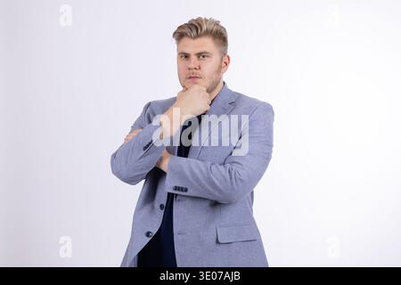 Nachdenklicher Mann im grauen Blazer, der mit Hand am Kinn denkt Stockfoto
