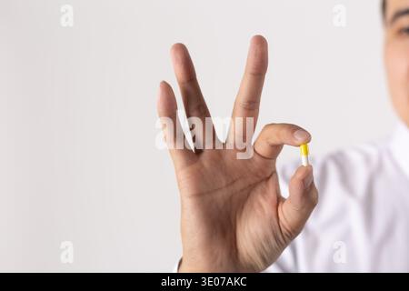 Nahaufnahme eines Mannes, der eine einzelne Pille hält Stockfoto