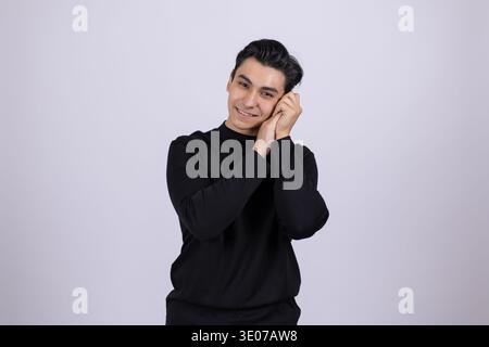 Mann mit schwarzem Rollkragen, der auf den Händen schläft Stockfoto