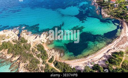 Drohnenblick auf den Karydi Strand in Vourvourou, Chalkidiki, Griechenland, fotografiert in einem Srping. Klares Flachwasser, glatte Felsformationen und ruhige Küste Stockfoto