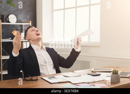 Junger, trauriger Geschäftsmann im Büro mit Rechnungen Stockfoto