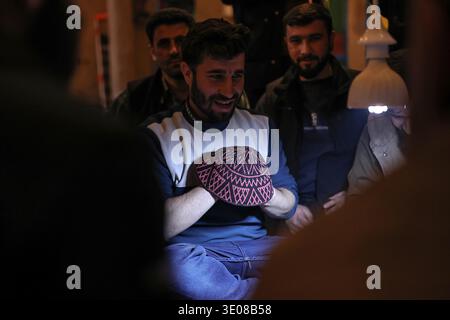 Erbil, Region Kurdistan, Irak. März 2026. Irakische kurdische Männer spielen das traditionelle Folklore-Spiel Klaw Klawne (Caps Game) während einer Ramadan-Nacht im Mali Hassan Hayran, einem historischen Schlammhaus im Shanidar Park in Erbil im Irak. Nach Iftar versammeln sich die Einheimischen, um das beliebte Ratesspiel zu spielen, ein geschätzter Ramadan-Brauch, der das kulturelle Erbe der Region Kurdistan bewahren soll (Foto: © Sabur Rashid/ZUMA Press Wire), NUR REDAKTIONELLE VERWENDUNG! Nicht für kommerzielle ZWECKE! Stockfoto