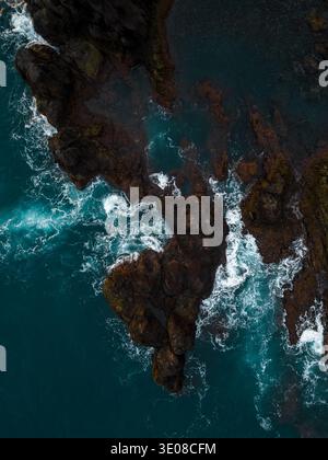 Luftaufnahme der Wellen, die an einer felsigen vulkanischen Küste in Madeira, Portugal zusammenbrechen Stockfoto