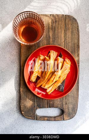 Blick von oben auf geräucherte Lachsfilets mit einem Glas Apfelessig auf einem hölzernen Schneidebrett Stockfoto