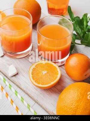 Frischer Orangensaft mit Obst auf Holztisch Stockfoto