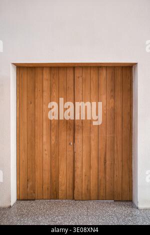 Große braune Doppeltür aus Holz, die an der Zementwand verschlossen ist Stockfoto