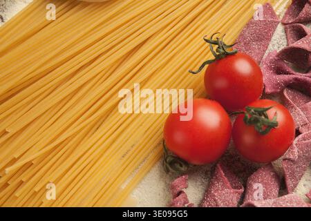 Collage aus Pasta, Tomaten und lila Pasta auf einer Oberfläche in einer Küche Stockfoto