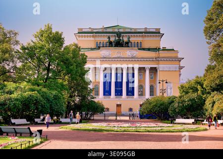 Die Leute laufen vor dem Alexandrinsky Theater auf dem Newski Prospekt in Sankt Petersburg, Russland. Das Gebäude ist hell und einladend. Stockfoto