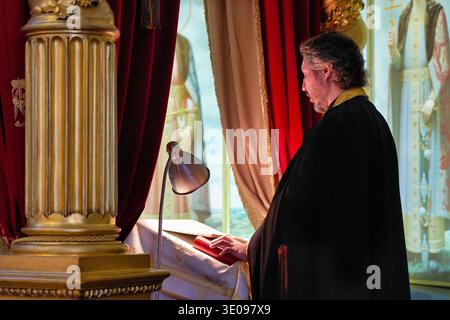 Ein Mann steht still und betet im Alexander-Newski-Lavra-Kloster in St. Petersburg. Die Einstellung zeigt Spalten und religiöse Symbole an. Stockfoto