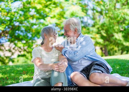 Wunderschönes, süßes Paar Senioren, die sich umarmen und einen zarten Moment draußen im grünen Park genießen und vor Glück lächeln. Zwei Rentner Stockfoto