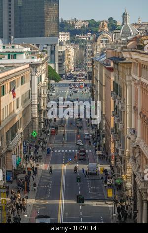 Via XX Settembre, Genova, Italien. Geschäftige zentrale Durchgangsstraße mit gemischtem Verkehr, Fußgängern, historischen Fassaden und modernen Hochhäusern. Stockfoto