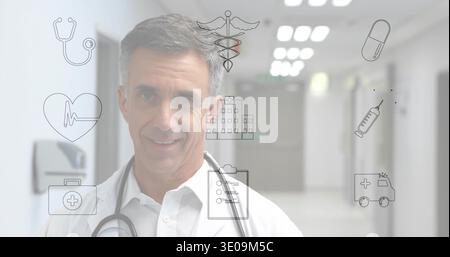 Standing Senior Doctor Facing Kamera in Krankenhaussaal, Laborkittel und Stethoskop mit medizinischen Ikonen Stockfoto