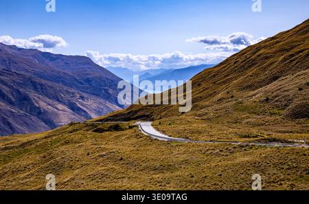 Crown Range Road, Otago, Südinsel, Neuseeland, Ozeanien. Panoramablick von der Crown Range Road nach Queenstown, Lake Wakatipu und den umliegenden mountai Stockfoto