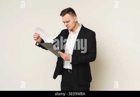 Ernster Mann mit Notizblock auf weißem Hintergrund Stockfoto