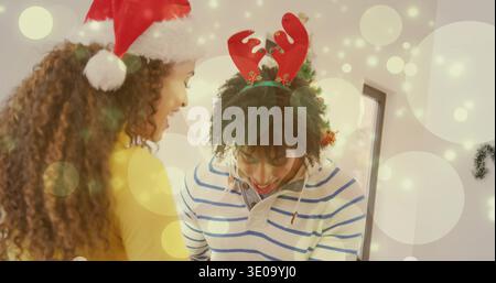 Eine gelehnte Frau und ein lächelnder Mann teilen einen ruhigen Moment zu Hause, tragen Santa-Hut und Geweih Stockfoto