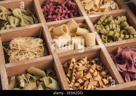 Verschiedene Arten von Pasta in einer Holzkiste mit verschiedenen Abschnitten für Abwechslung angeordnet Stockfoto