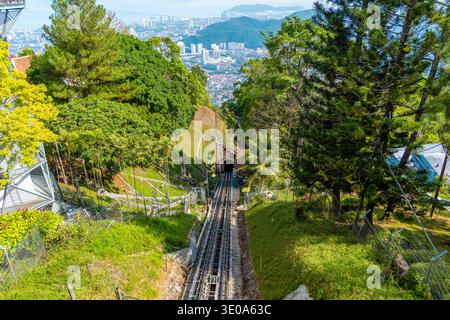 Seilbahngleise, die steilen Hügel durch den Tunnel hinabsteigen, Penang Hill mit Blick auf die Skyline von George Town, Malaysia Reisetourismus. Stockfoto
