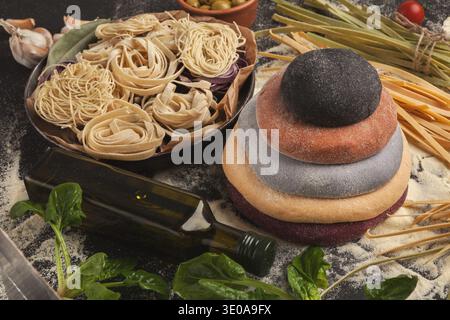 Verschiedene Nudelsorten und Zutaten in einer Collage auf einem Küchentisch zum Kochen angeordnet Stockfoto