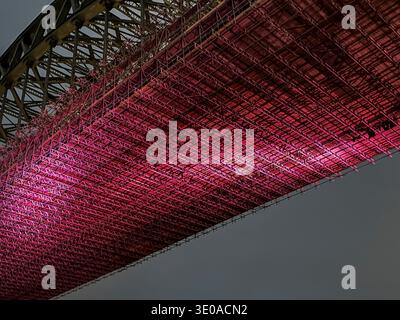 Die komplizierte Stahlkonstruktion der Tyne Bridge leuchtet nachts in leuchtendem Rot. Newcastle, England, Vereinigtes Königreich Stockfoto