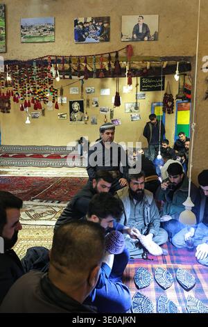 Erbil, Irak. März 2026. In Erbil, Irak, spielen am 10. März 2026 kurdische Männer das traditionelle Folklore-Spiel Klaw Klawne (Caps Game) während einer Ramadan-Nacht im Mali Hassan Hayran Heritage House in Erbil. Das Ratespiel ist ein beliebter Brauch nach dem Iftar in der Region Kurdistan mit dem Ziel, das kulturelle Erbe zu erhalten (Foto: Sabur Rashid/NurPhoto). Quelle: NurPhoto SRL/Alamy Live News Stockfoto