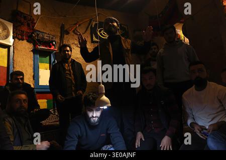 Erbil, Irak. März 2026. In Erbil, Irak, spielen am 10. März 2026 kurdische Männer das traditionelle Folklore-Spiel Klaw Klawne (Caps Game) während einer Ramadan-Nacht im Mali Hassan Hayran Heritage House in Erbil. Das Ratespiel ist ein beliebter Brauch nach dem Iftar in der Region Kurdistan mit dem Ziel, das kulturelle Erbe zu erhalten (Foto: Sabur Rashid/NurPhoto). Quelle: NurPhoto SRL/Alamy Live News Stockfoto