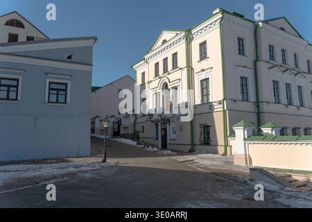 Minsk, Weißrussland - 8. März 2026: Historische weiße Gebäude mit grüner Zierleiste und weißrussischer Flagge auf der Fußgängerstraße Muzykalny Lane im Zentrum von Minsk Under Stockfoto